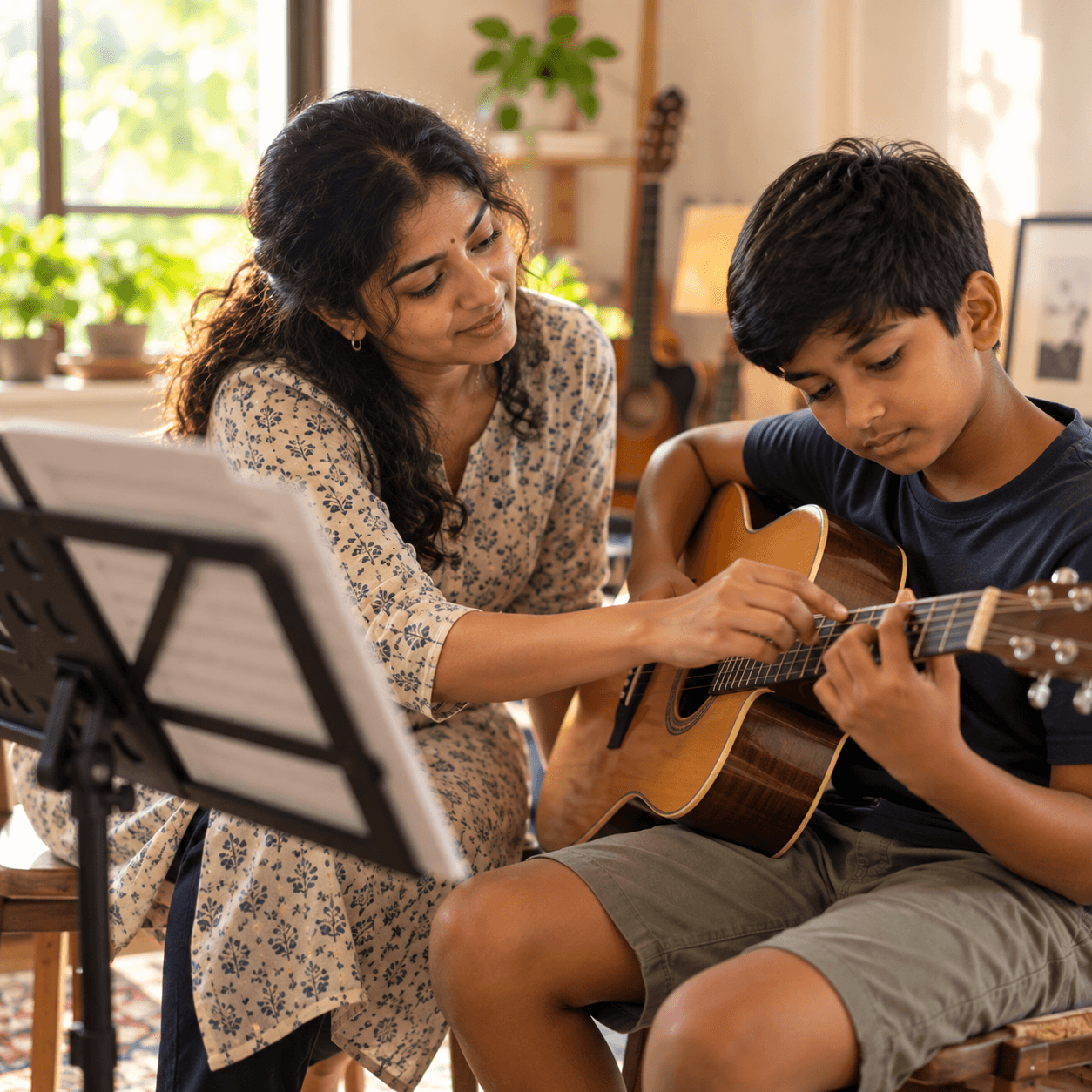A music teacher showing a boy how to finger a chord on a guitar